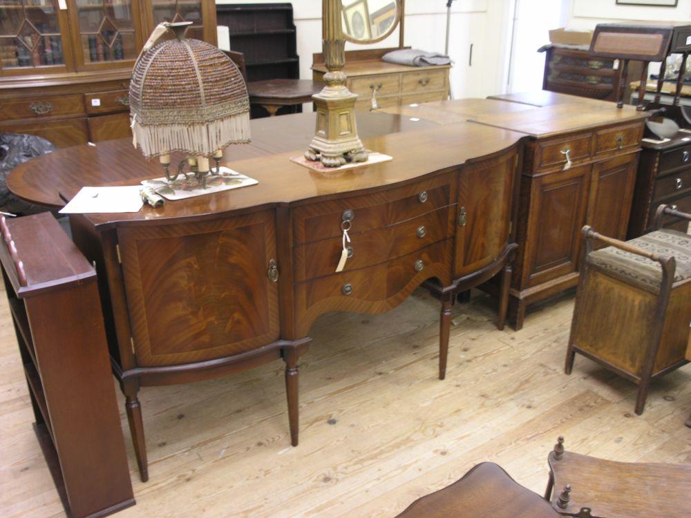 Appraisal: A reproduction mahogany sideboard with three central drawers flanked by