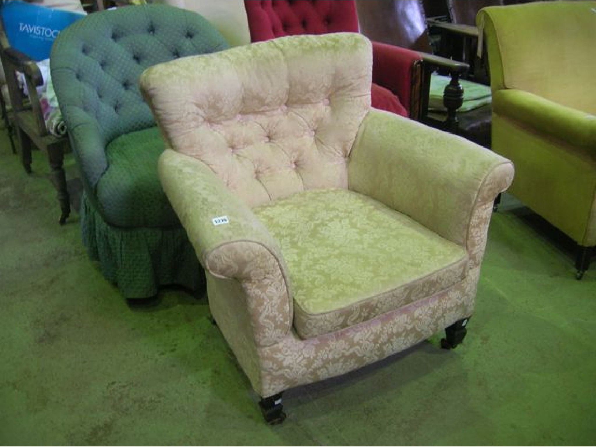 Appraisal: An Edwardian low deep buttoned back armchair with swept and