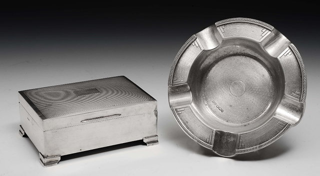 Appraisal: A silver cigarette boxon ogee supports with engine turned decoration