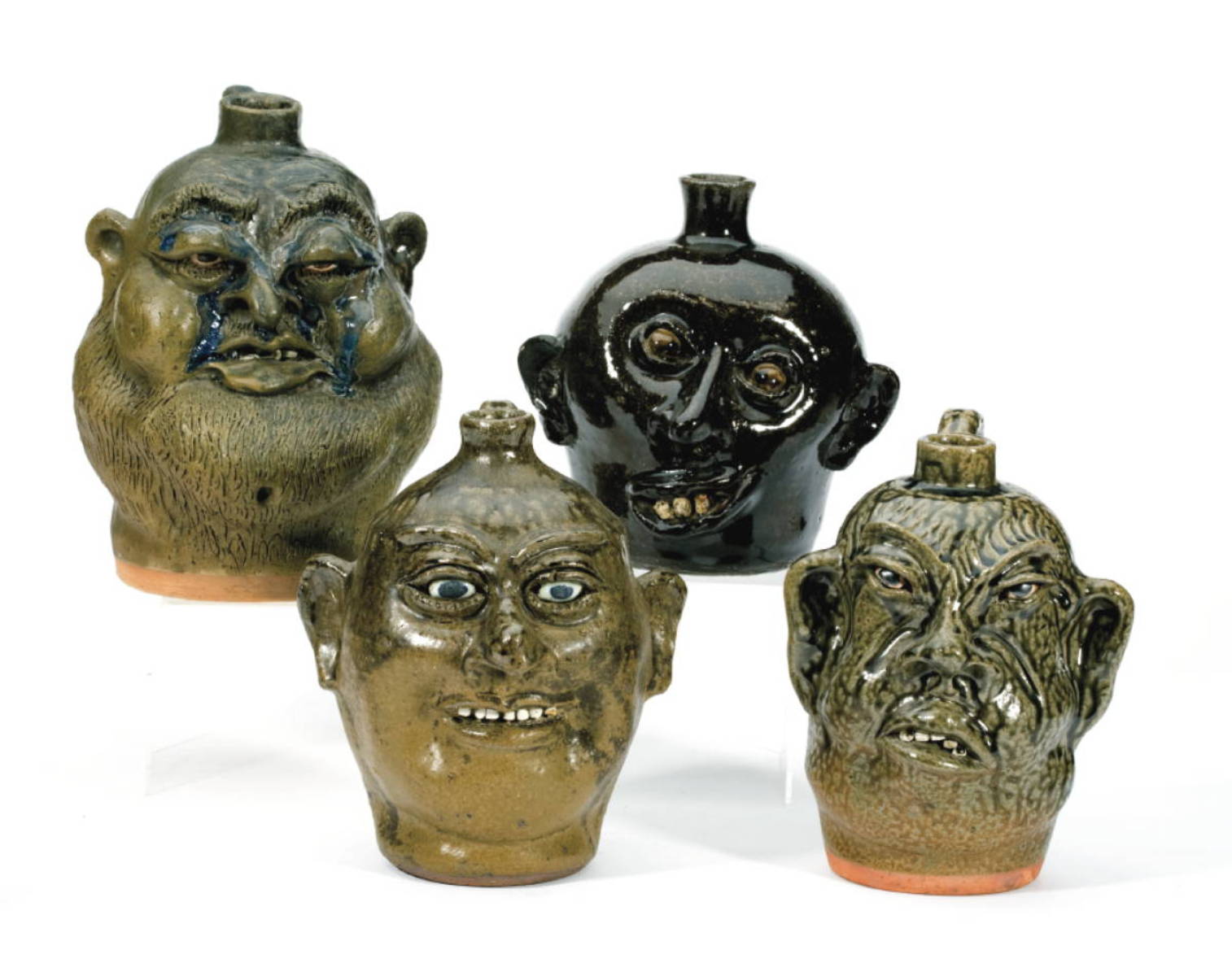 Appraisal: FOUR SOUTHERN MOLDED AND GLAZED POTTERY GROTESQUE FACE JUGS EACH