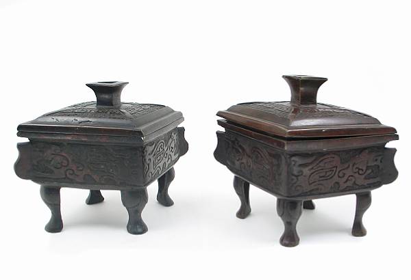 Appraisal: A pair of Chinese patinated bronze lozenge shaped covered vessels