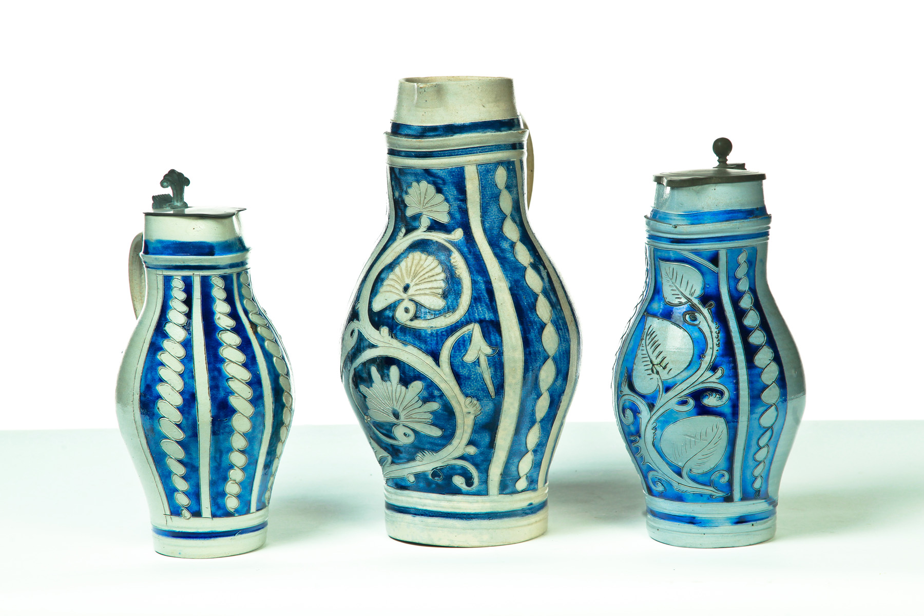 Appraisal: THREE WESTERWALD-STYLE STONEWARE PITCHERS Probably Germany late th-early th century