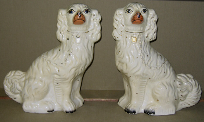 Appraisal: PAIR OF STAFFORDSHIRE POTTERY DOGS Each seated molded collar with