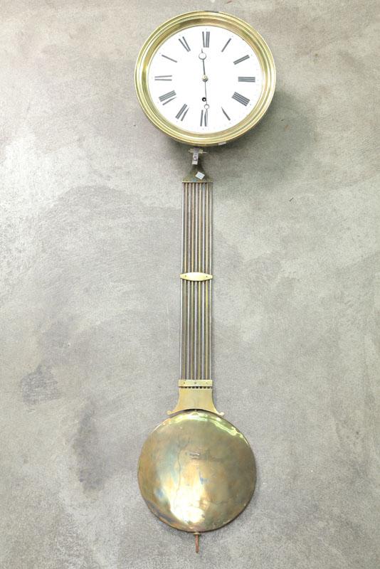 Appraisal: WAG-ON-THE-WALL CLOCK Brass works surround weight pendulum and porcelain dial