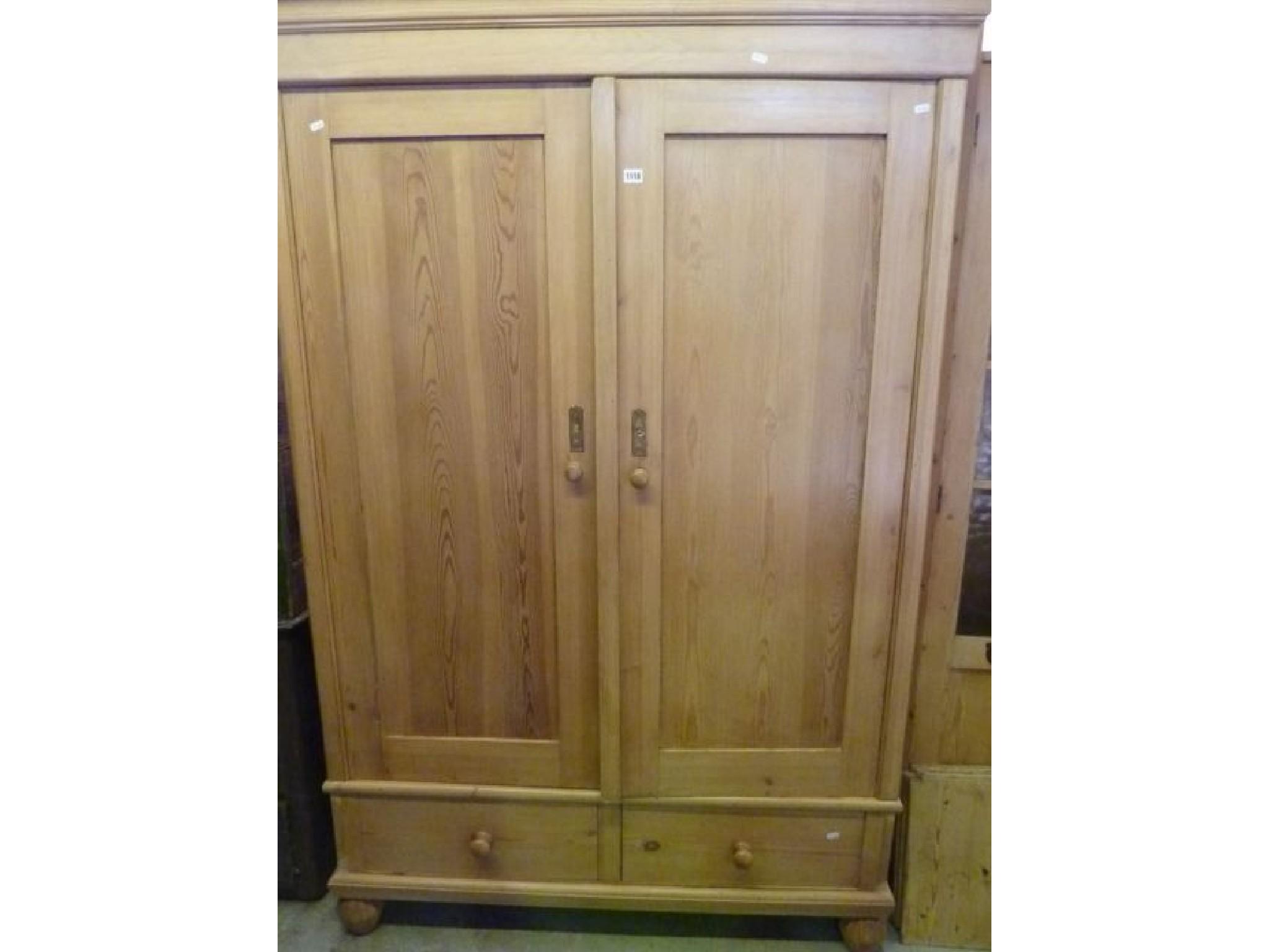 Appraisal: A continental stripped and waxed pine knock down wardrobe enclosed