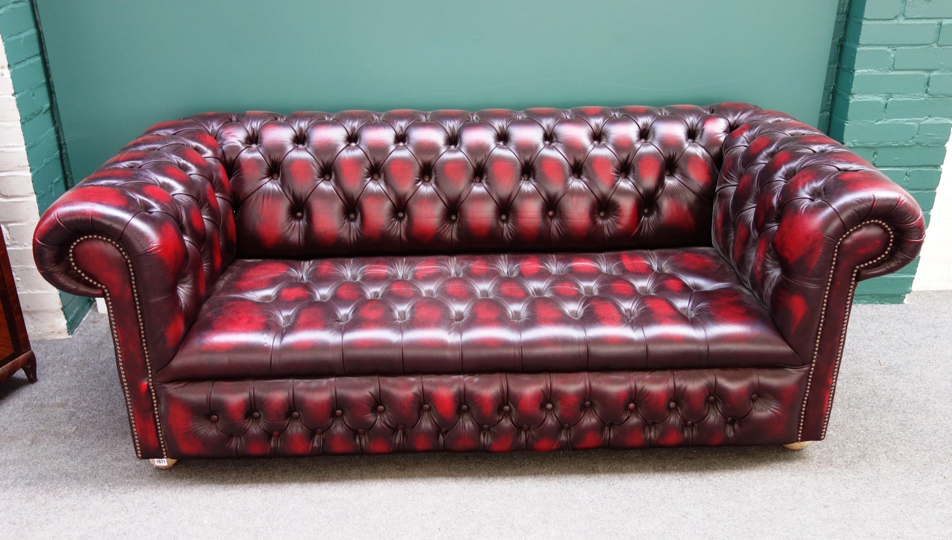 Appraisal: A th century red leather button upholstered Chesterfield sofa with