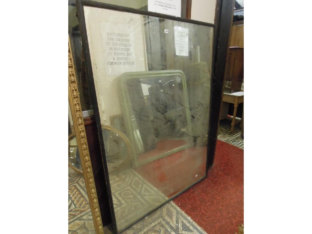 Appraisal: A large wall mirror with simple ebonised rectangular moulded frame