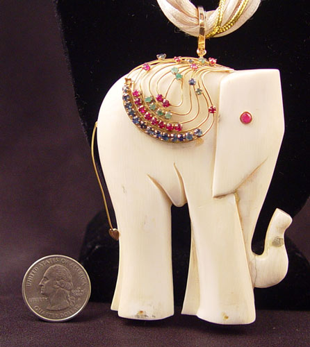 Appraisal: LARGE IVORY GEMSTONE ELEPHANT PENDANT Sapphires emeralds and rubies decorate