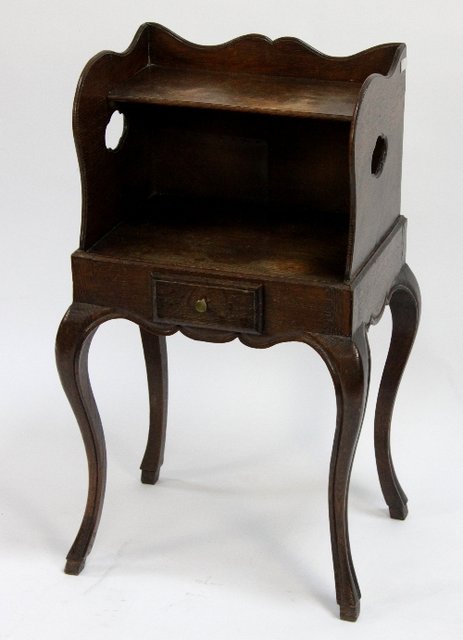 Appraisal: A carved oak bedside table with pierced quatrefoils to the