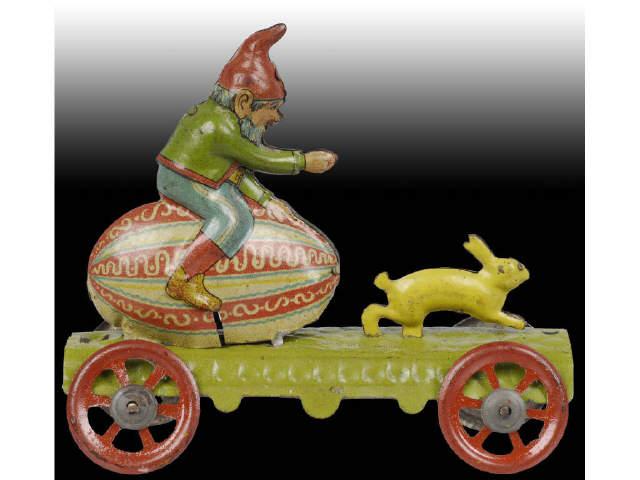 Appraisal: German Tin Litho Gnome Sitting on Egg with Rabbit Description