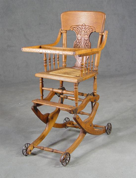 Appraisal: Child's Oak Convertible High Chair Circa Forged iron wheels Chair