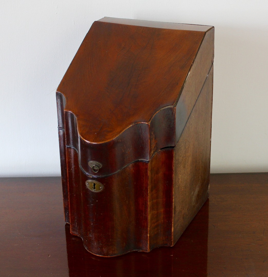 Appraisal: A George III mahogany serpentine knife box with hinged lid