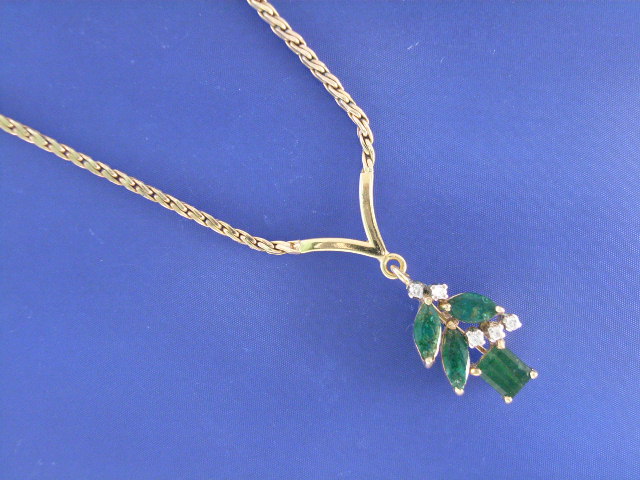 Appraisal: An ct gold four emerald and five diamond V shaped