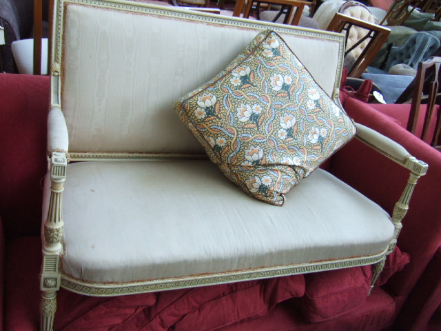 Appraisal: A Louis XVI style cream painted sofa the guilloche carved