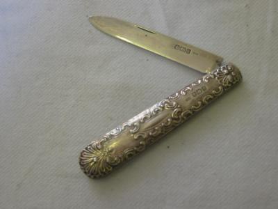 Appraisal: AN EDWARDIAN FOLDING FRUIT KNIFE with scroll embossed handle long