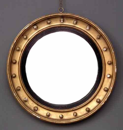 Appraisal: A gilt framed circular convex wall mirror the deep moulded