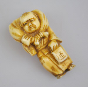 Appraisal: A Japanese ivory netsuki of a man carrying a sack