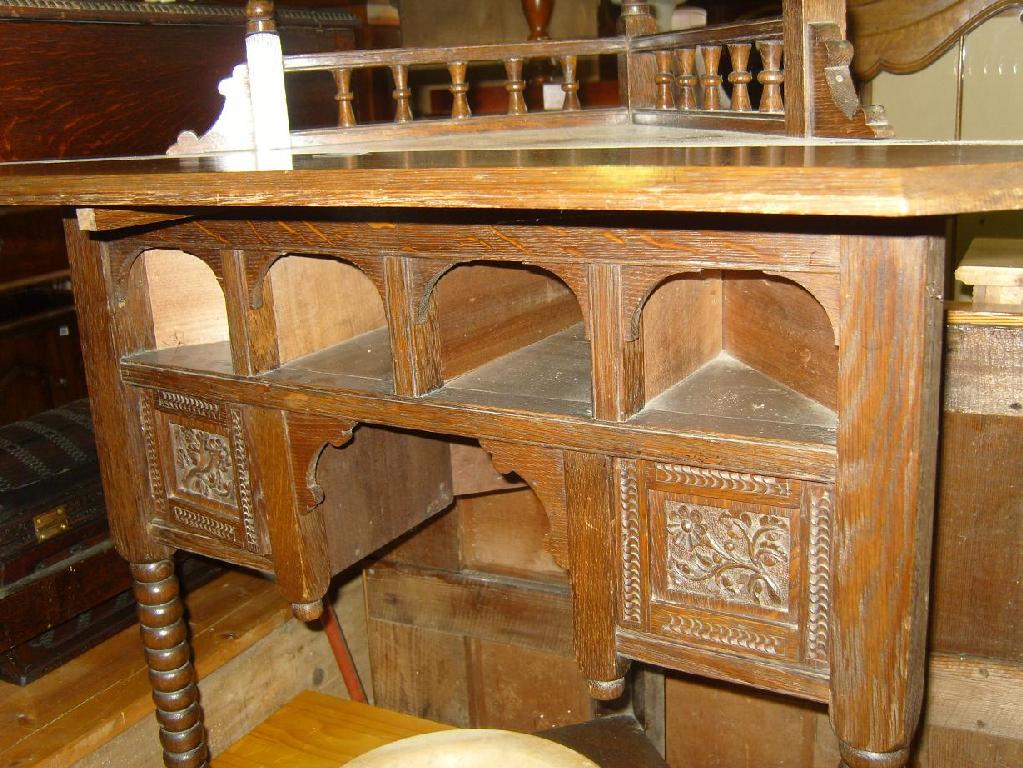 Appraisal: An Edwardian oak corner table of stylised form with turned