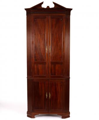 Appraisal: A mahogany corner cupboard with broken dentil cornice fitted shaped