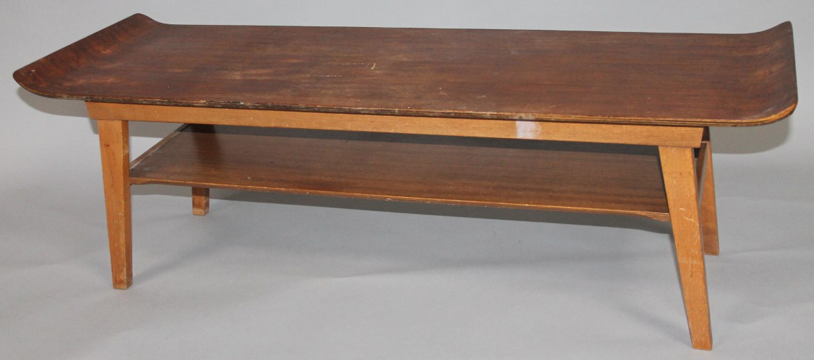 Appraisal: A retro teak coffee table the shaped rectangular top raised