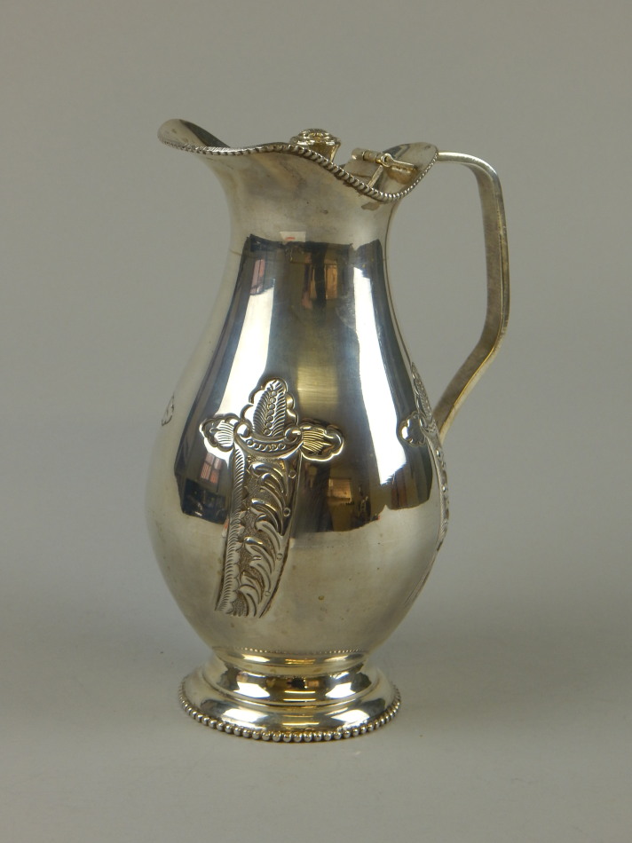 Appraisal: A white metal lidded water jug of baluster shape chased