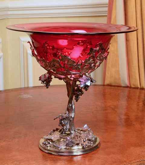 Appraisal: A CIRCULAR CRANBERRY GLASS BOWL on a white metal stand