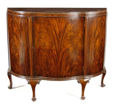 Appraisal: A mahogany serpentine front side cabinet with a central door