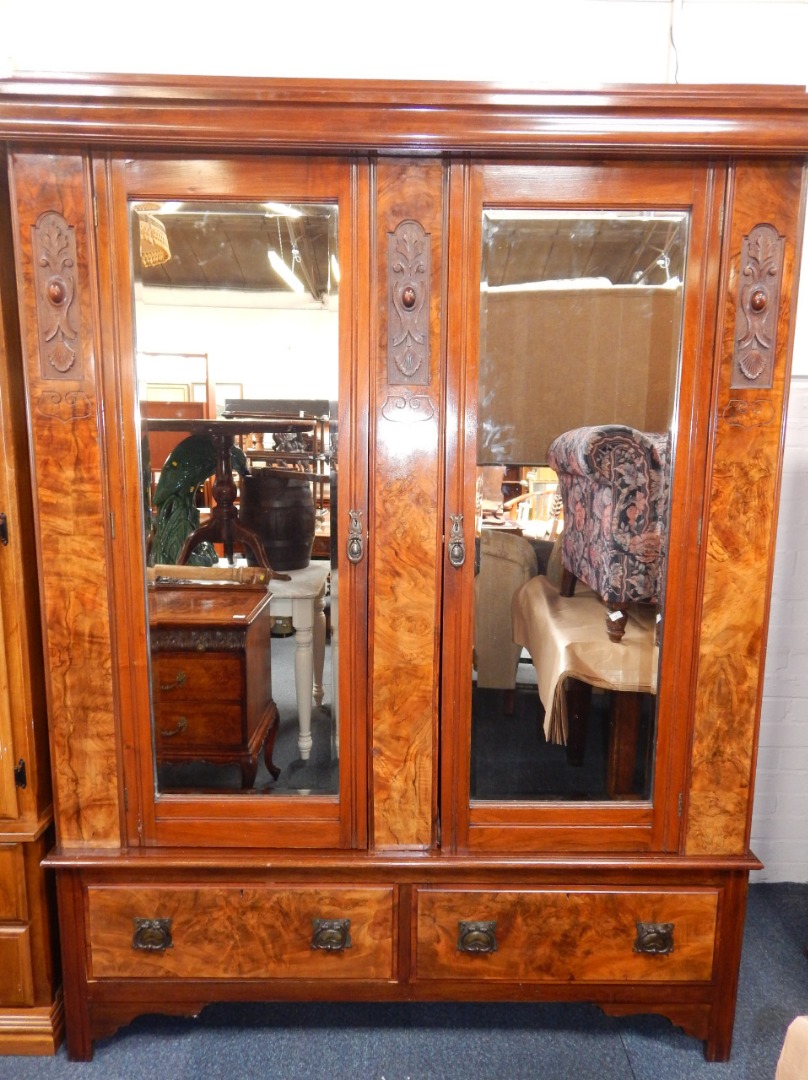 Appraisal: A Victorian mahogany and walnut double wardrobe the pediment above