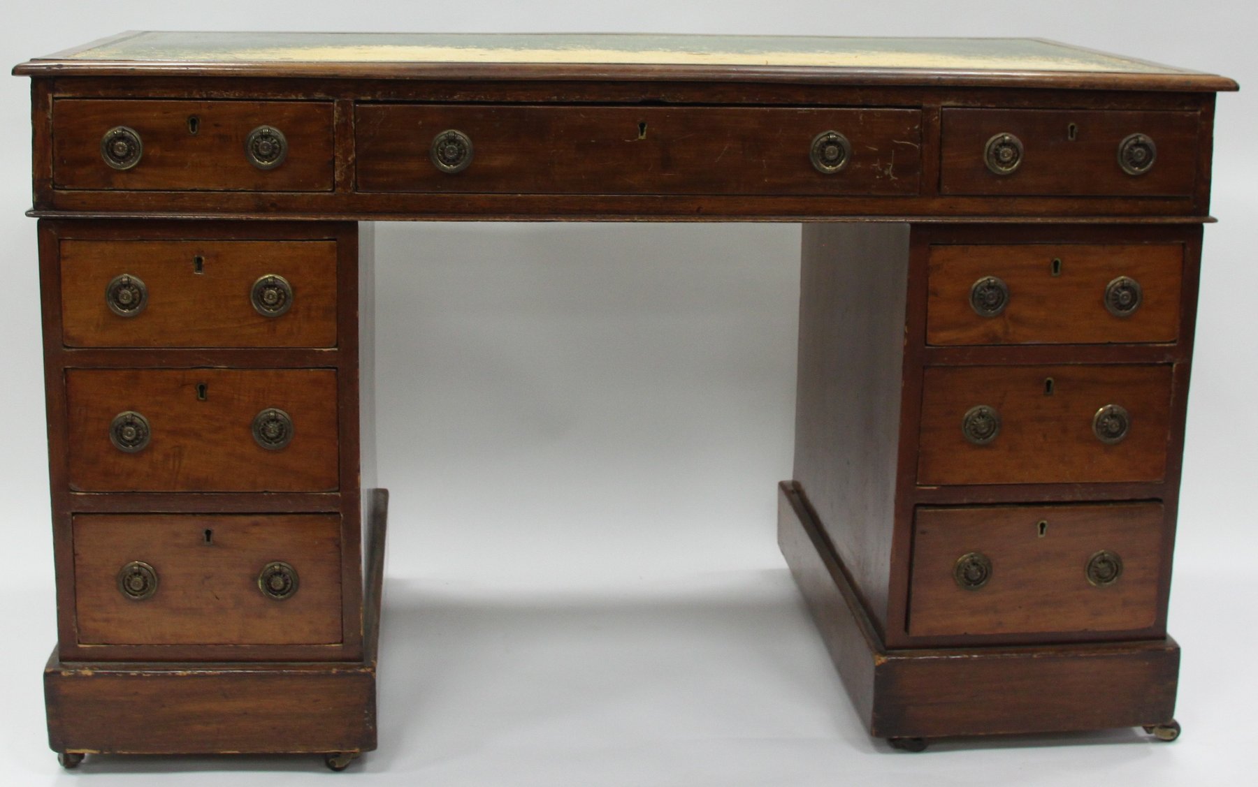 Appraisal: A mahogany kneehole desk fitted a surround of nine drawers