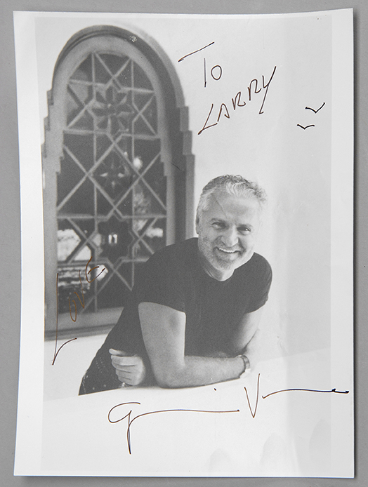 Appraisal: GIANNI VERSACE AUTOGRAPHED BLACK AND WHITE PHOTOGRAPH Seen leaning over