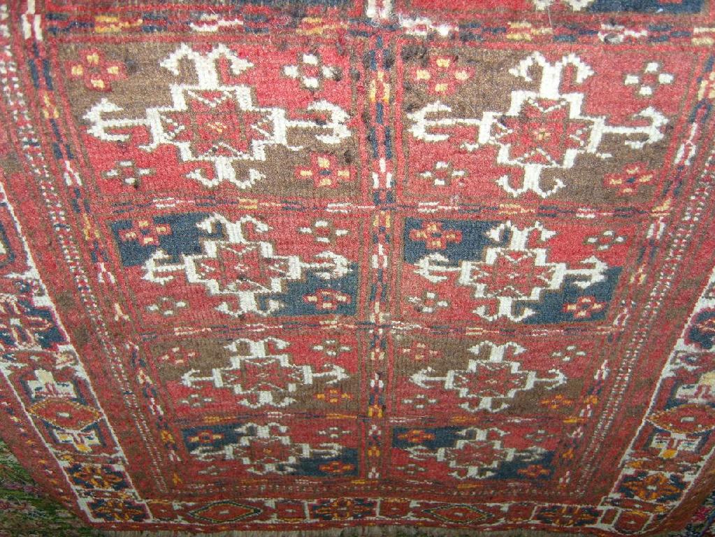 Appraisal: A small red ground eastern wool rug with repeating geometric