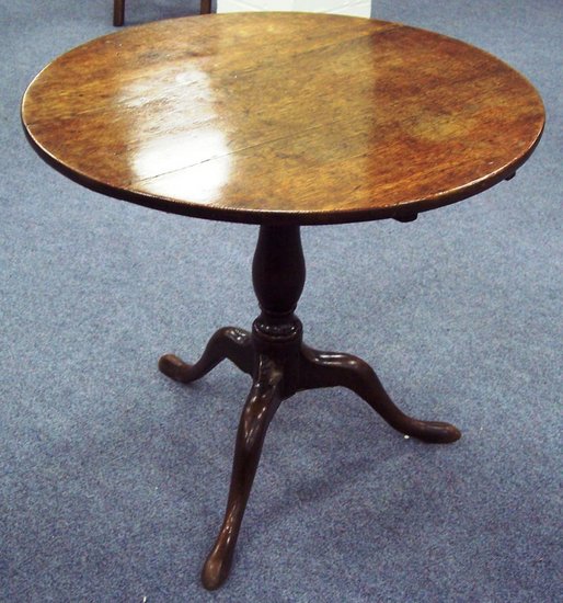 Appraisal: A circular oak table on a turned column and tripod