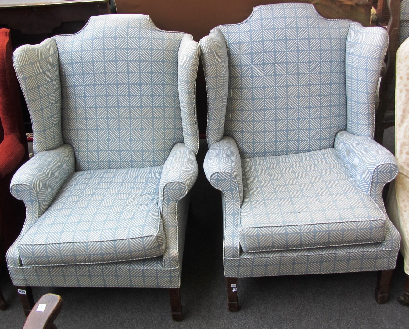 Appraisal: A pair of late th century mahogany framed wingback armchairs