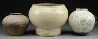 Appraisal: THREE POTTERY STORAGE JARS The lot comprising of a large