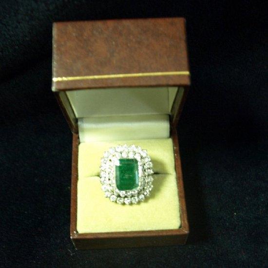 Appraisal: A rectangular emerald ring with cluster surround of forty four