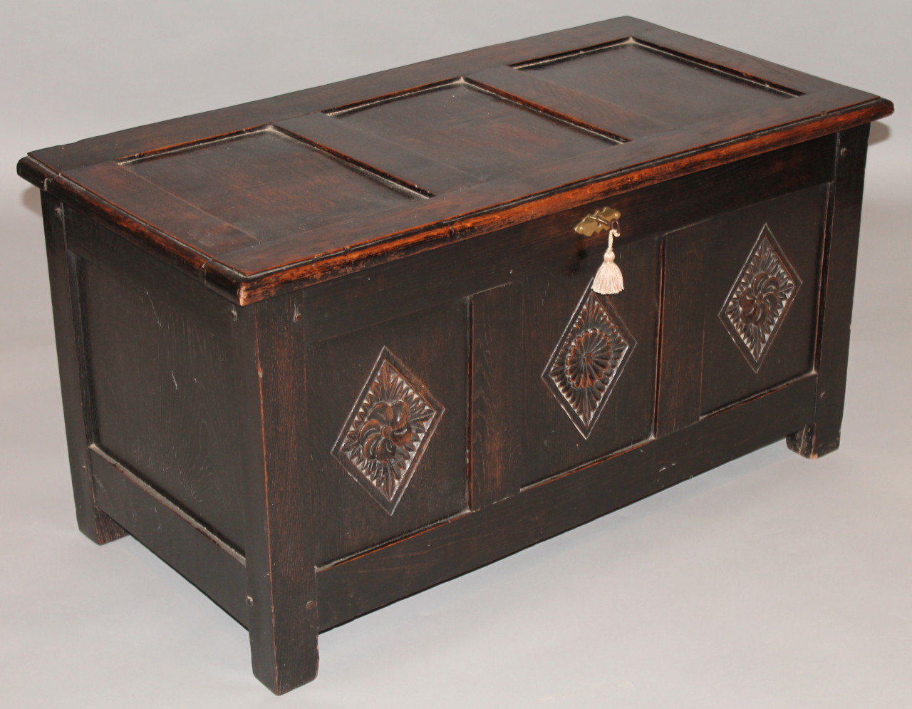 Appraisal: An thC style oak three panelled coffer the carved hinged