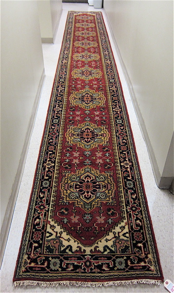 Appraisal: HAND KNOTTED ORIENTAL LONG RUG Indo-Persian nine geometric medallion and