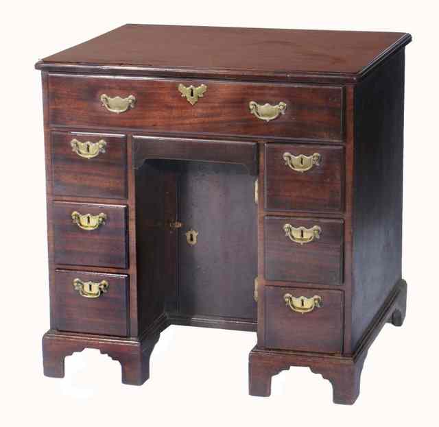 Appraisal: A GEORGE II MAHOGANY KNEEHOLE DESK fitted with an arrangement