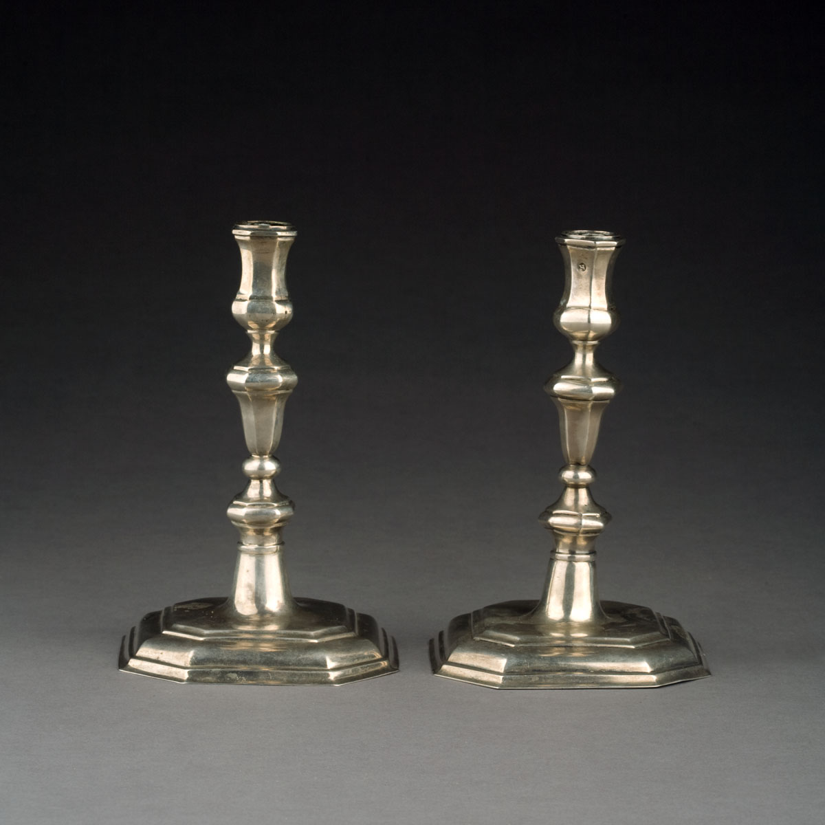 Appraisal: PAIR OF GERMAN SILVER CANDLESTICKS PROBABLY EIGHTEENTH CENTURY Each paneled