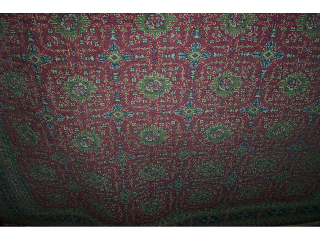 Appraisal: A pink ground wool rug with cream green and blue