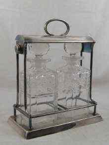 Appraisal: A stylish spirit tantalus the two square cut glass decanters