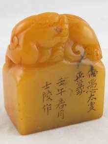 Appraisal: A Chinese yellow hardstone seal with carved kylin x x