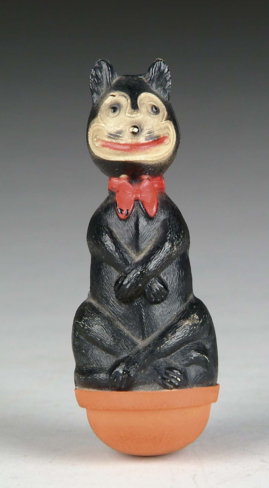 Appraisal: CELLULOID CAT ROLY-POLY Rocking black cat sits Buddha-style balancing on