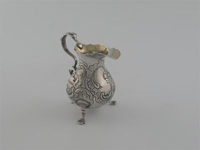 Appraisal: A George II baluster cream jug on three feet embossed