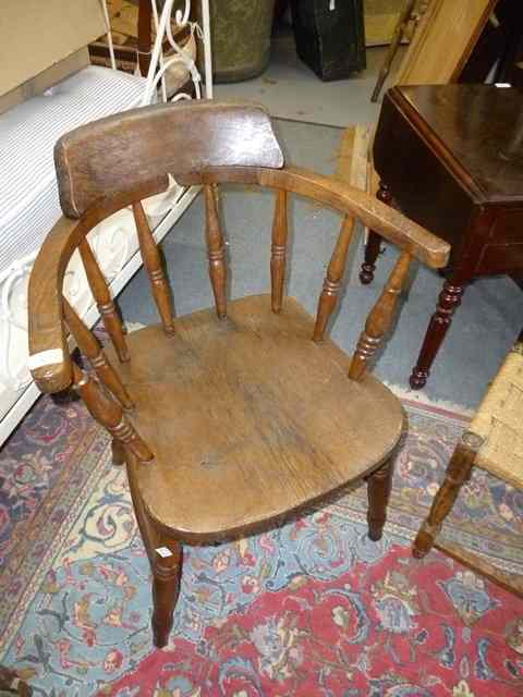 Appraisal: AN OLD OAK CAPTAIN'S CHAIR with spindle back standing on