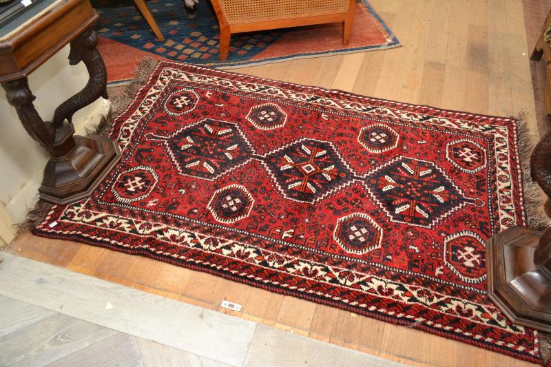 Appraisal: A SMALL AFGHAN TRIBAL RUG IN CRIMSON TONES