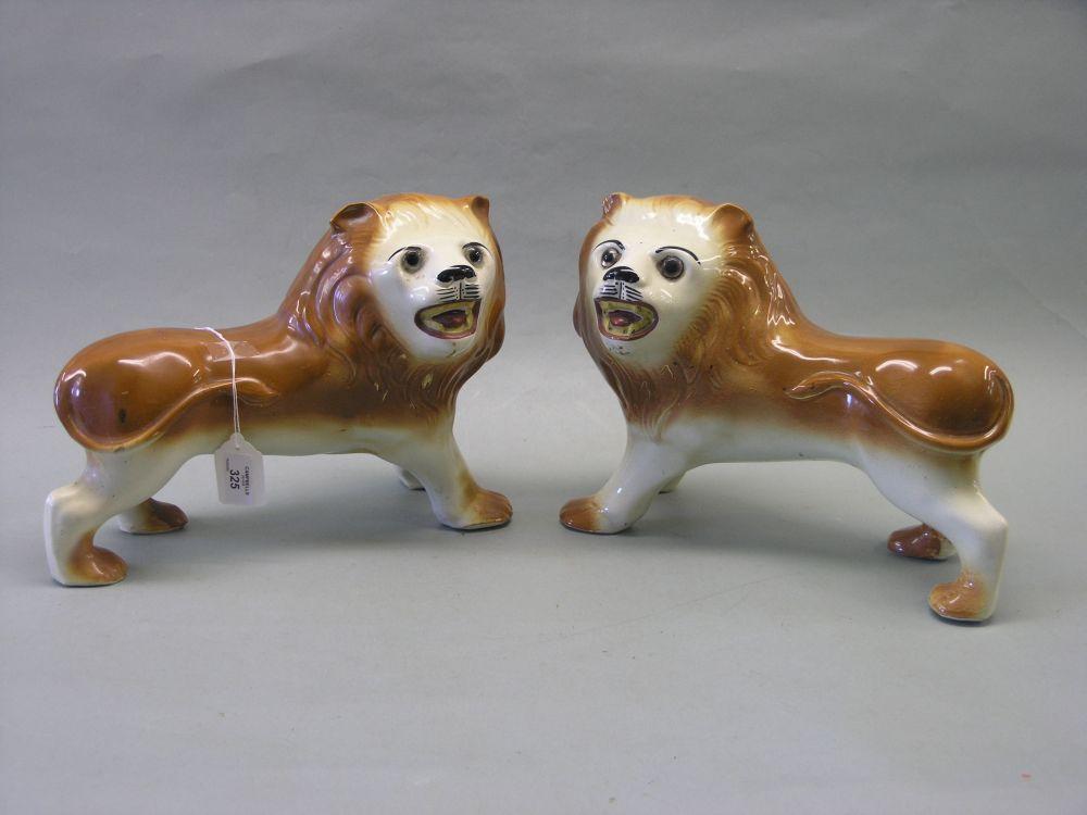 Appraisal: A pair of Staffordshire earthenware lion models each with glass