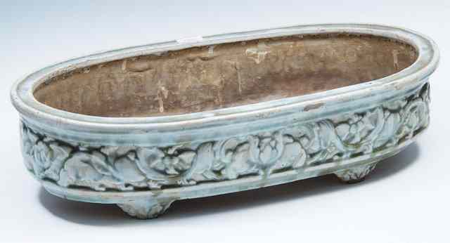 Appraisal: A CHINESE CELADON GLAZED POTTERY PLANTER oval with embossed foliate