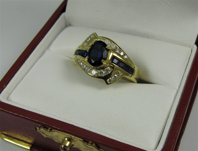 Appraisal: SAPPHIRE DIAMOND AND K GOLD RING centering an oval-cut blue