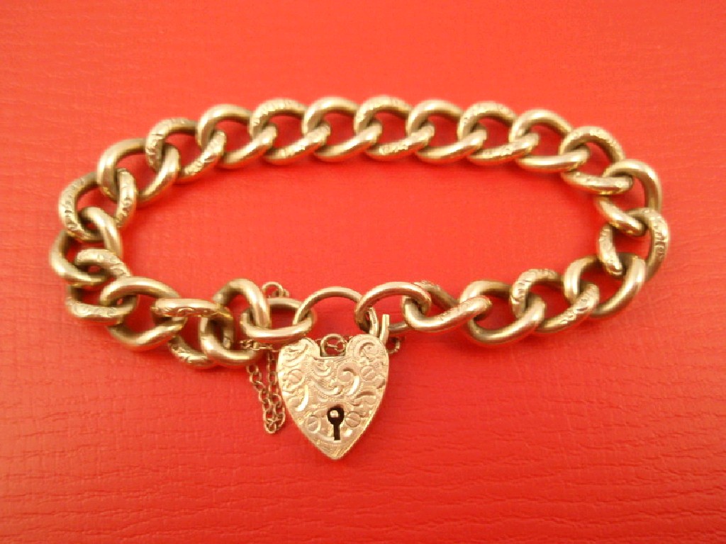 Appraisal: A ct gold engraved curb link bracelet with padlock clasp